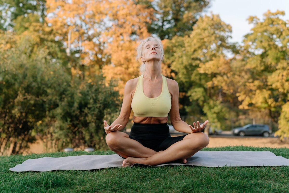 Femme assise dans l herbe pratiquant la respiration consciente pour apaiser les ruminations mentales