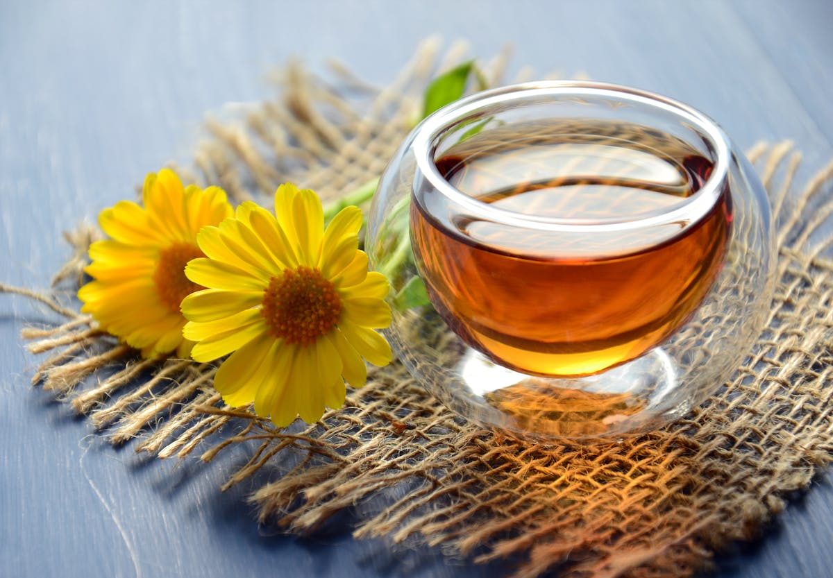 Tasse de tisane fumante posée près du lit pour un rituel du soir apaisant